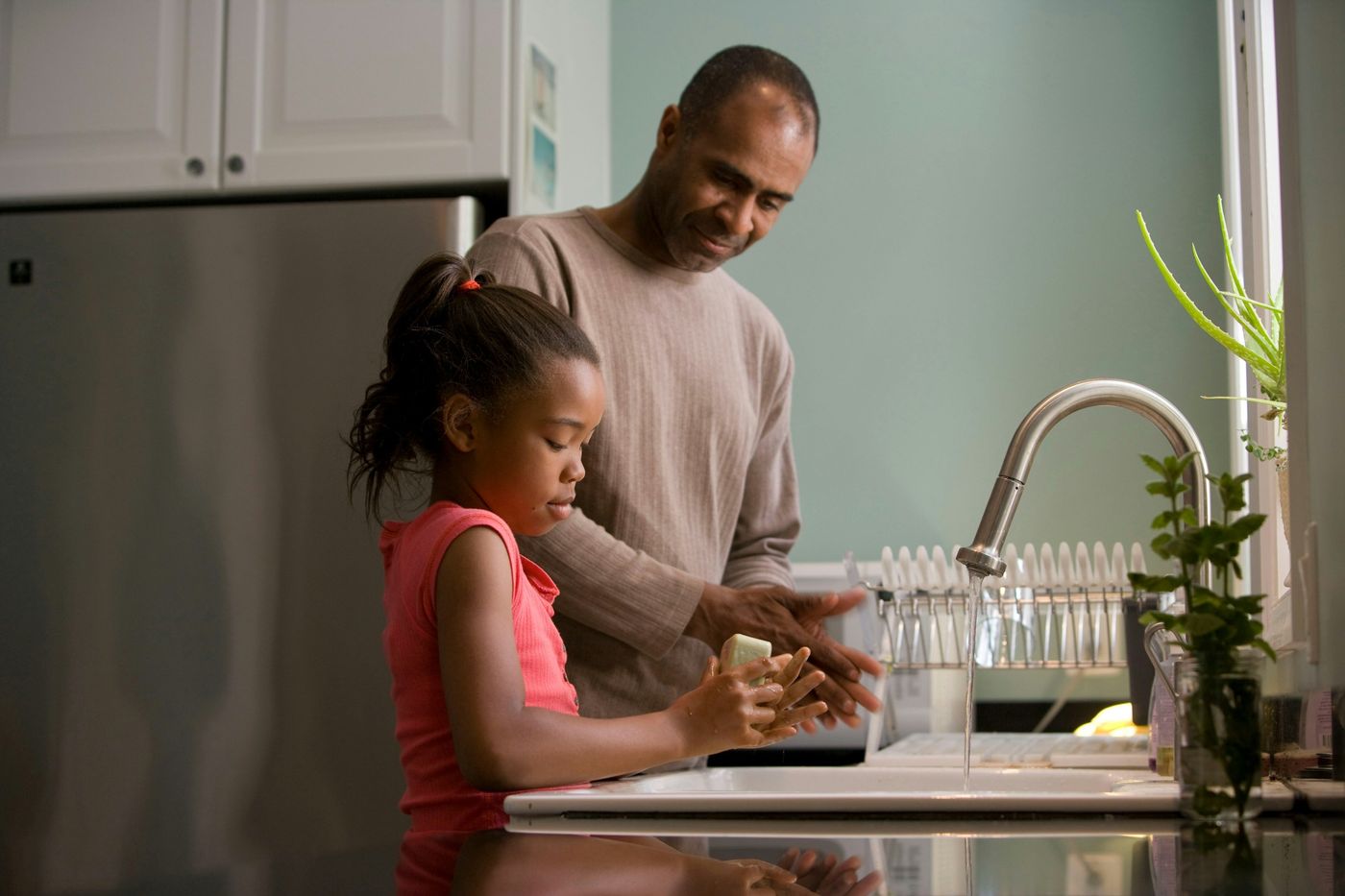 A father and his daughter cooking together at the kitchen counter