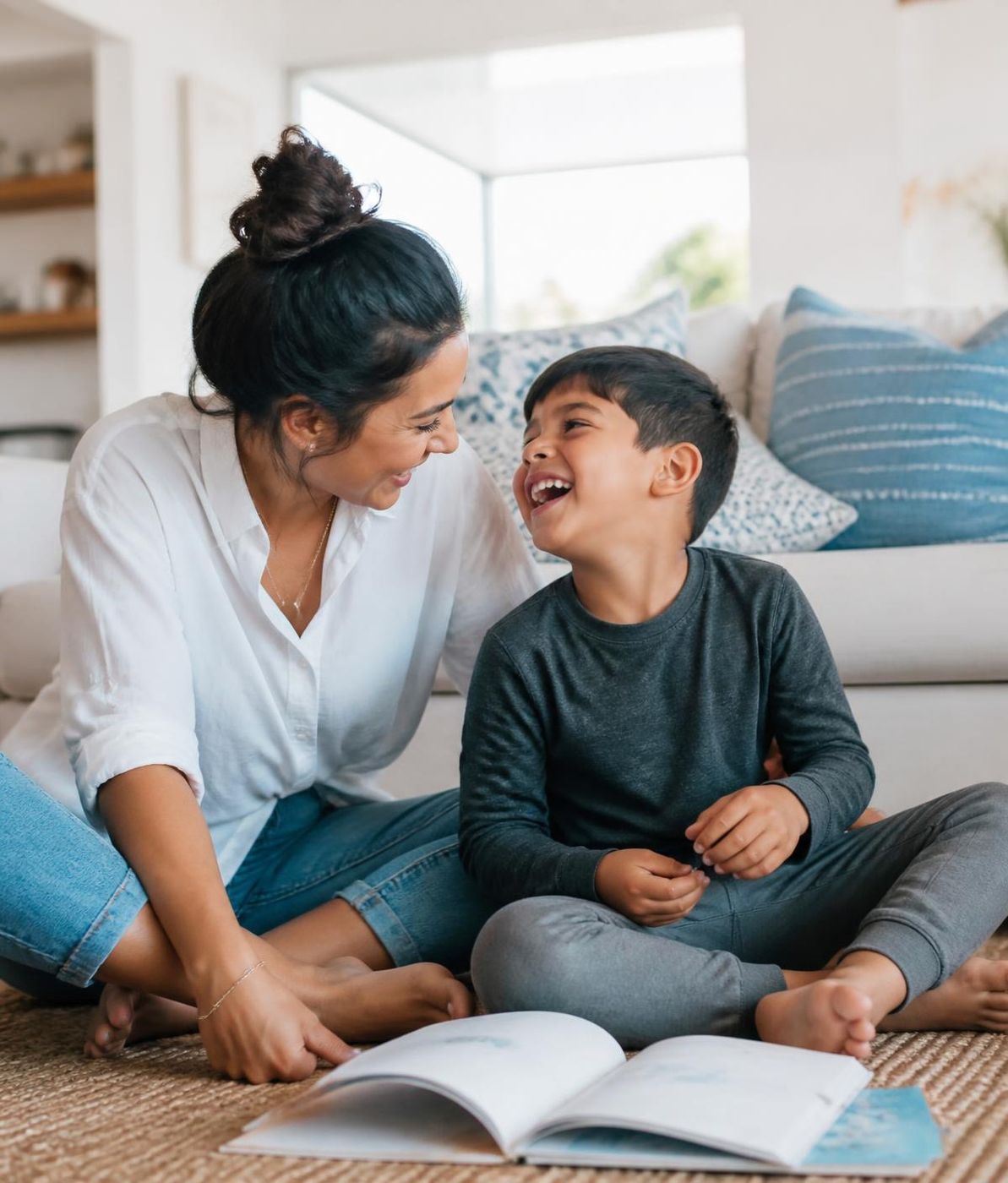 A mother and her son laughing together over a book at home