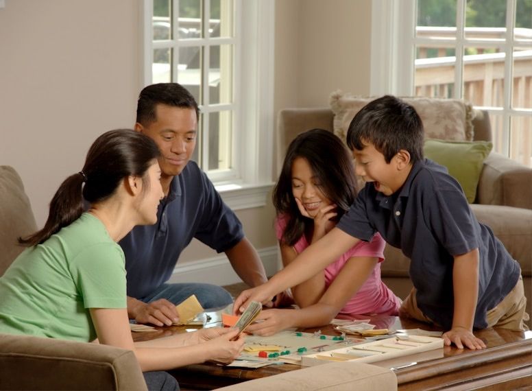 A family playing a board game together around a coffee table