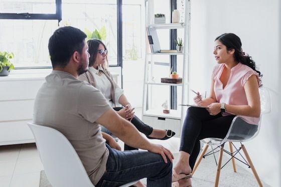 A specialist in conversation with two parents in a calm, light-filled room